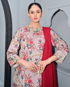 Woman wearing a floral dress with a red dupatta against a neutral background