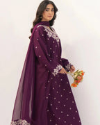 Woman wearing a purple traditional outfit with white patterns, holding flowers against a white background
