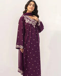 Woman wearing a purple dress with white patterns on a white background