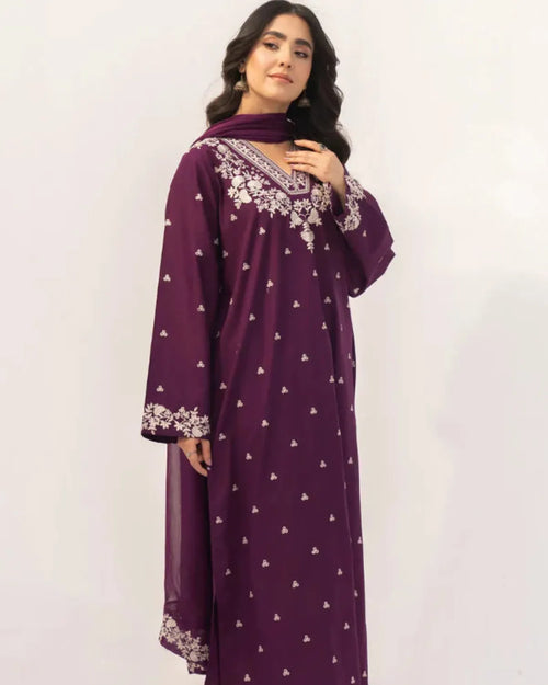 Woman wearing a purple dress with white patterns on a white background