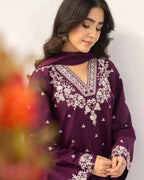 Woman wearing a purple embroidered outfit with a blurred background