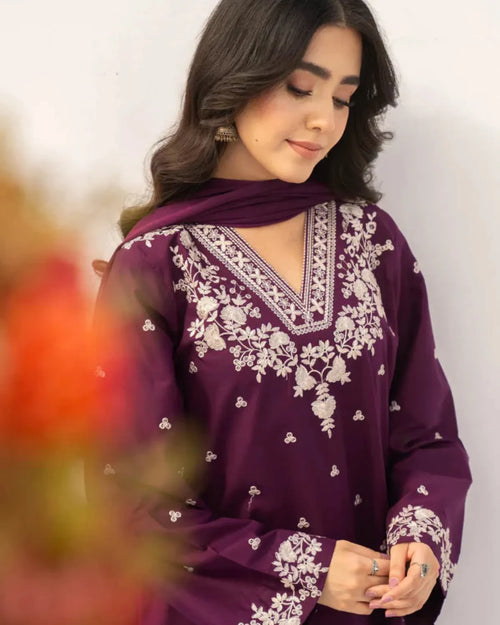 Woman wearing a purple embroidered outfit with a blurred background