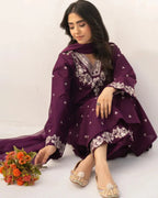 Woman in a purple traditional outfit with floral patterns sitting on a white background