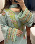 Light blue embroidered top with floral patterns worn by a person.