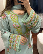 Light blue embroidered top with floral patterns worn by a person.