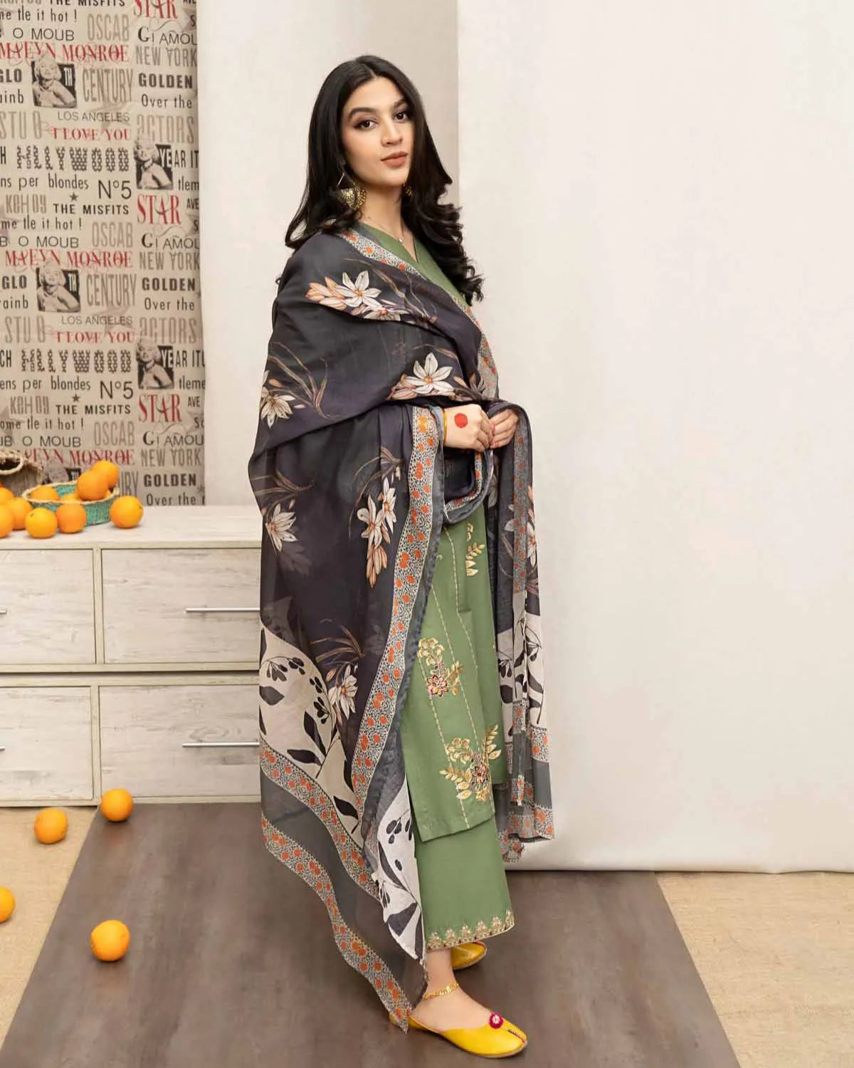 Woman in a traditional outfit standing in a room with decorative elements.