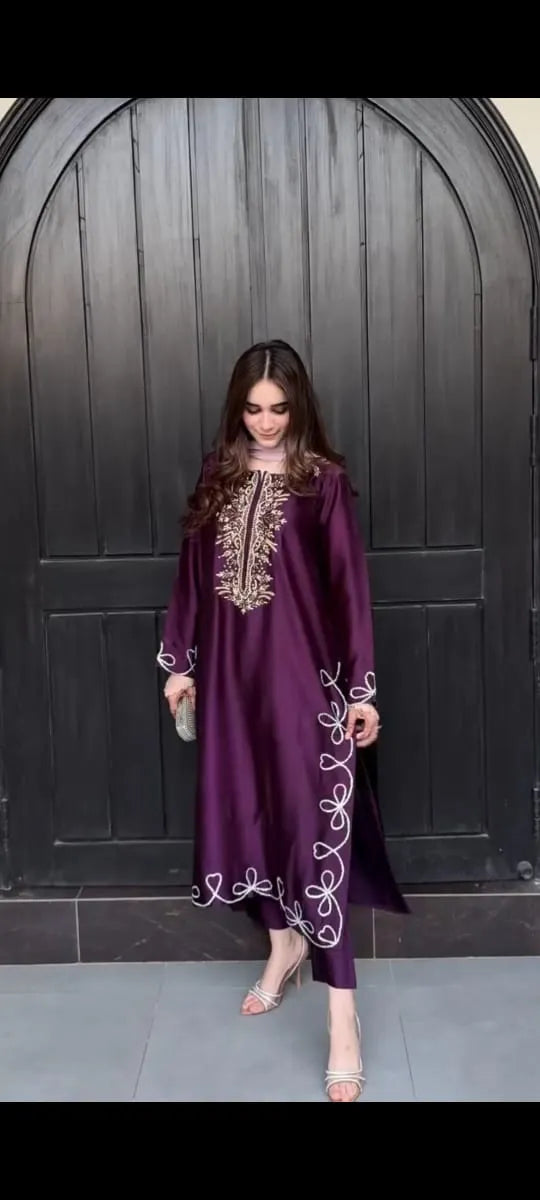 Woman wearing a purple embroidered dress against a dark background