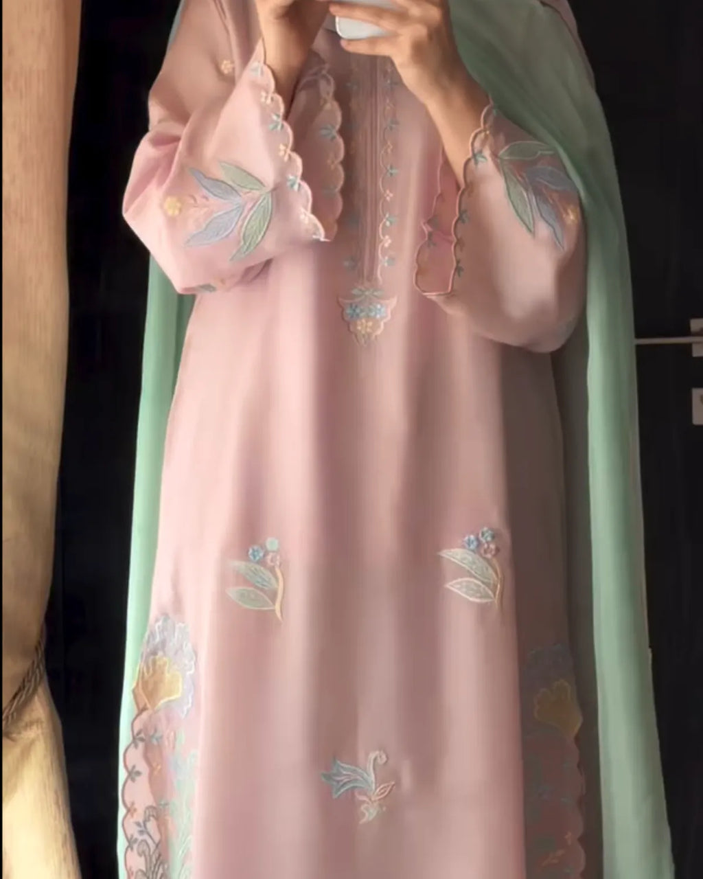 Pink embroidered dress with green dupatta against a dark background