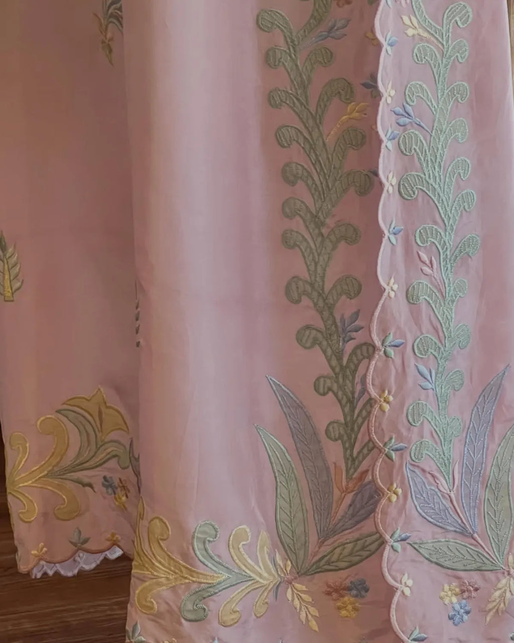 Embroidered fabric with floral patterns on a pink background