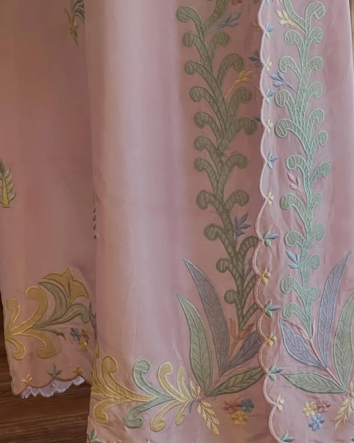 Embroidered fabric with floral patterns on a pink background