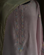 Close-up of a garment with intricate embroidery on a dark background