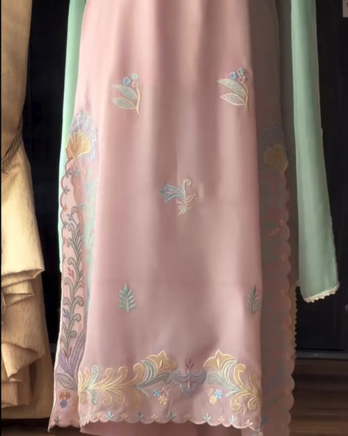 Pink dress with floral embroidery on a green background