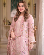 Woman wearing a pink embroidered outfit in an indoor setting