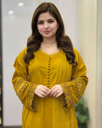 Woman wearing a yellow outfit with lace details indoors