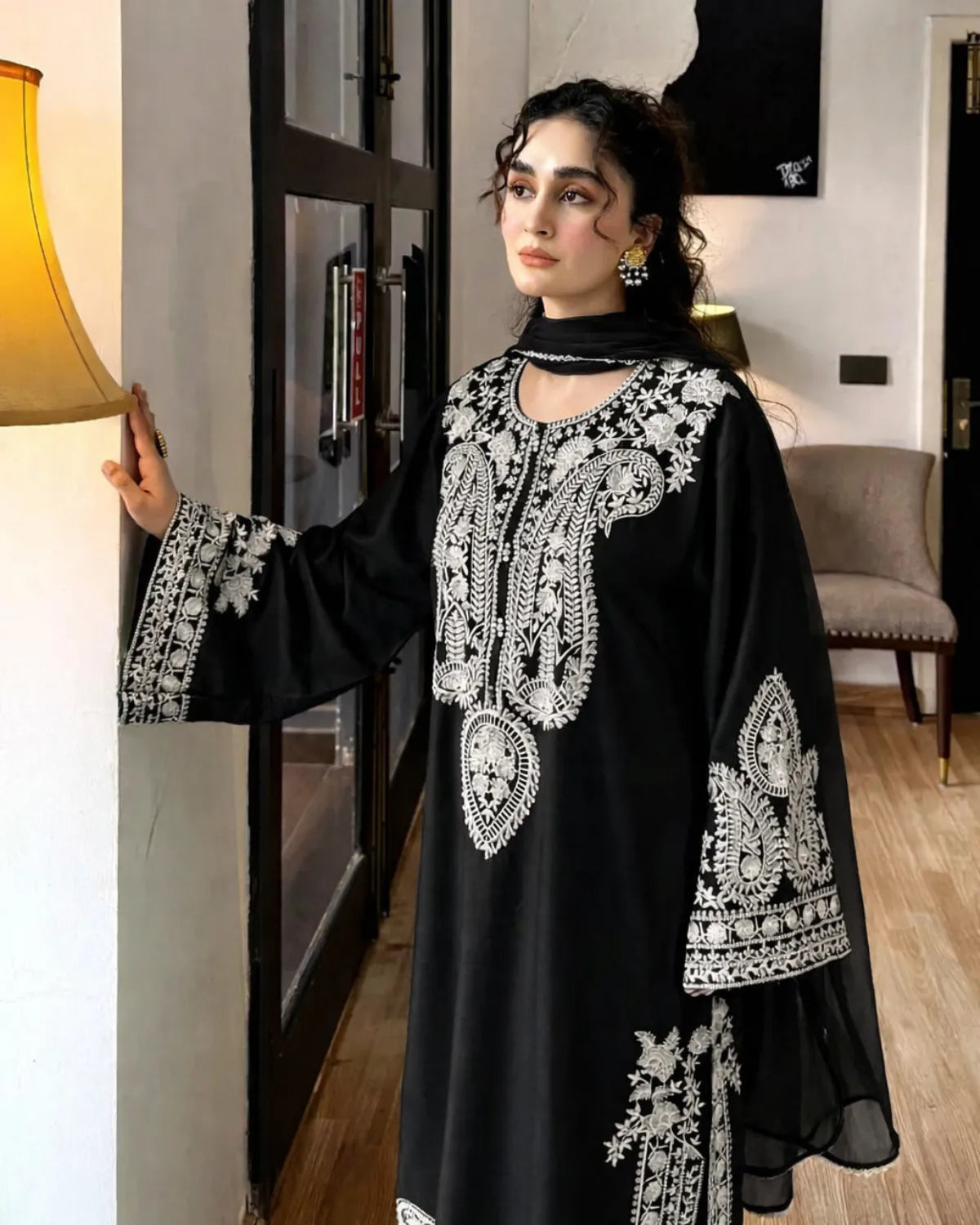 Woman wearing a black embroidered dress in an indoor setting