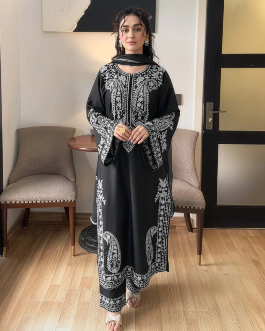 Woman wearing a black and white patterned outfit in an indoor setting.