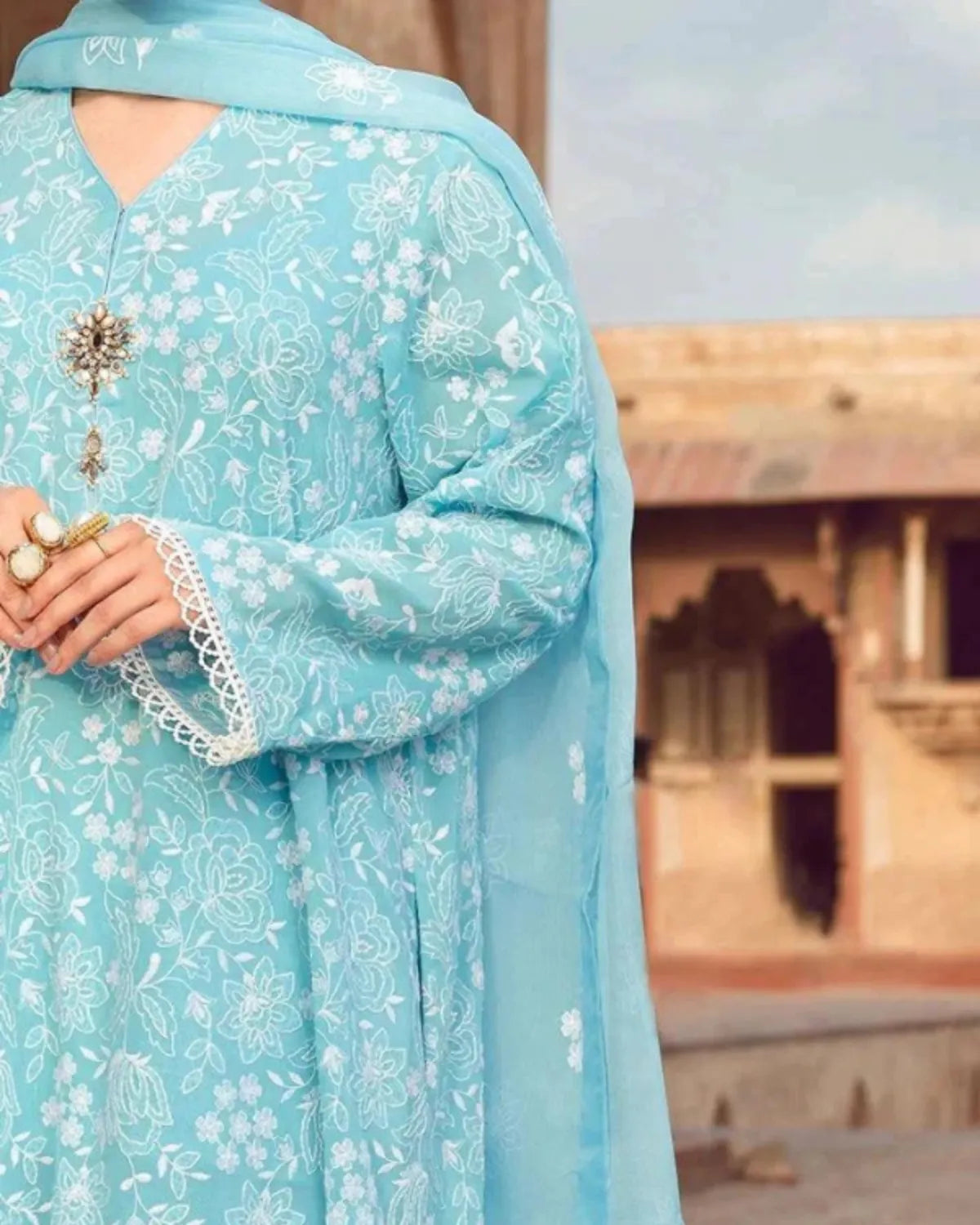 Light blue traditional outfit with floral patterns in an outdoor setting